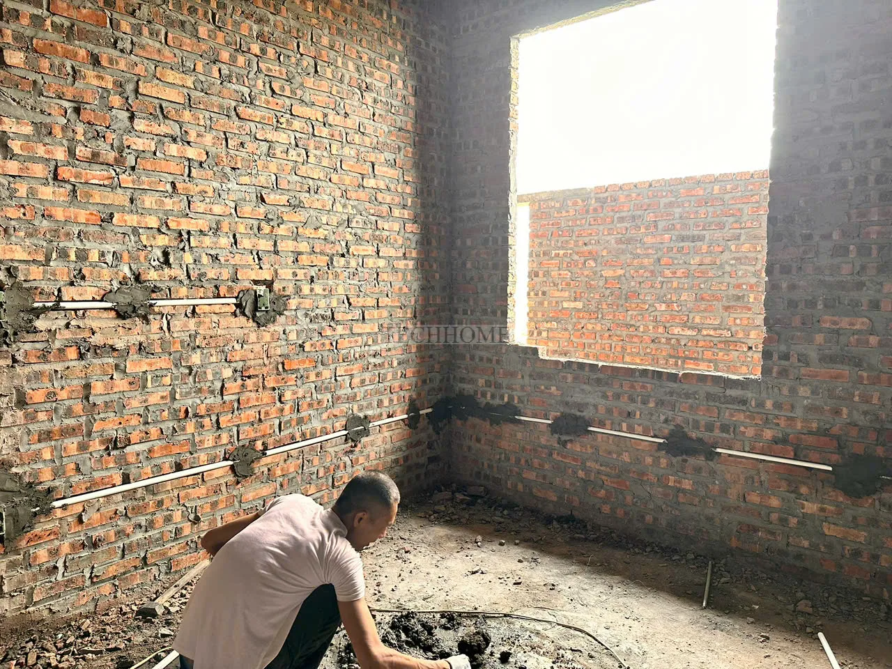 Thợ thi công đang xử lý đường ống điện nước âm tường chuyên nghiệp và gọn gàng.